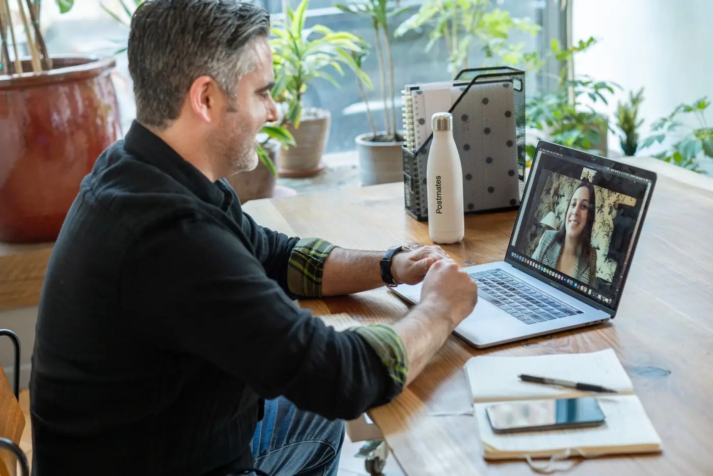 A man on a video call with a customer at his desk